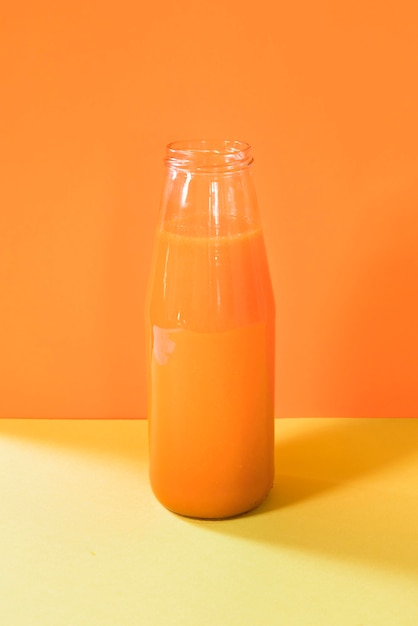 Gratis foto natuurlijke oranje smoothie in fles