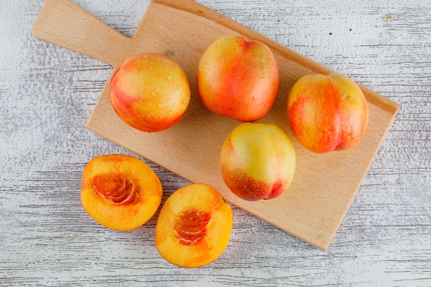 Nectarines op grungy en snijplank tafel. plat lag.