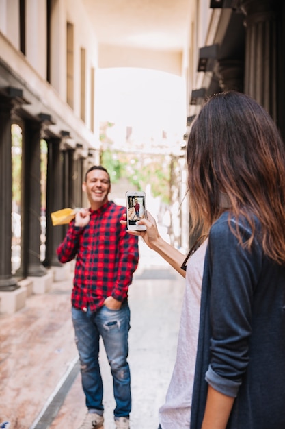 Gratis foto neem foto van lachende vriendje met smartphone