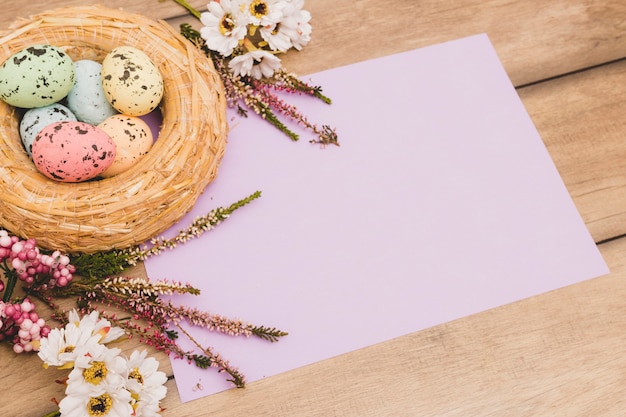 Nest en bloemen in de buurt van papier