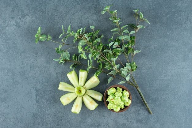 Netjes gesneden appel gerangschikt met een decoratieve plant en een kleine kom popcorn snoep op marmeren achtergrond. Hoge kwaliteit foto