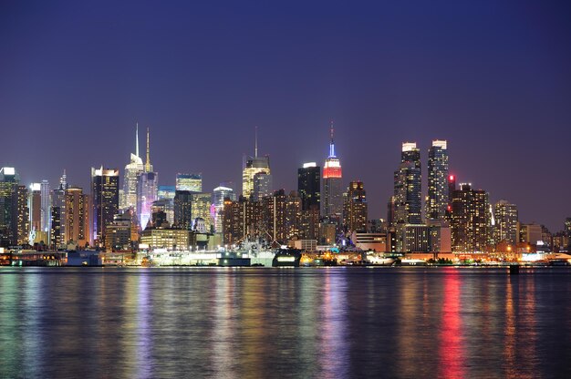 New York City Manhattan midtown skyline 's nachts met licht reflectie over Hudson River gezien vanaf de waterkant van New Jersey Weehawken.