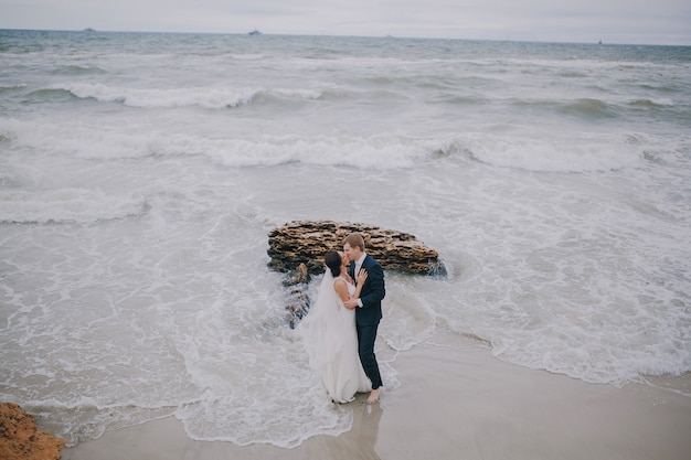 Gratis foto newlyweds zoenen op het strand