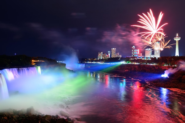 Niagarawatervallen 's nachts verlicht door kleurrijke lichten met vuurwerk