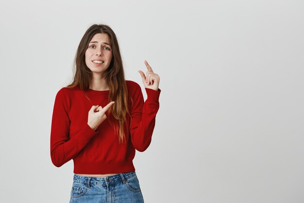 Niet onder de indruk meisje klaagt over de maat en toont iets kleins of kleins