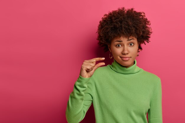 Niet veel zal genoeg zijn. Niet onder de indruk gekrulde vrouw vormt een klein klein voorwerp, heeft weinig meer hulp en aandacht nodig