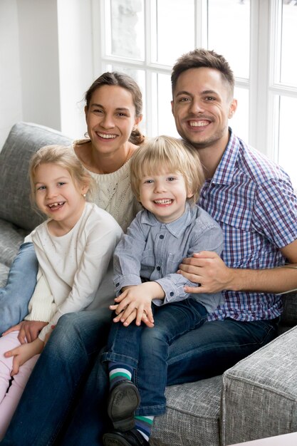 Nieuwe gelukkige ouders voor twee geadopteerde kinderen, familie verticaal portret
