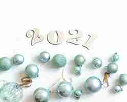 Gratis foto nieuwe jaarsamenstelling met houten nummer voor het komende jaar en blauwe geïsoleerde kerstmisballen.