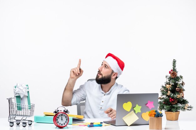 Nieuwsgierige jonge zakenman op kantoor die nieuwjaar of kerst aan het werk viert