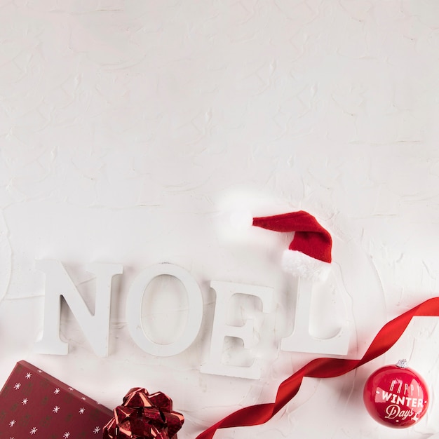 Noel inscriptie in de buurt van kerst bal en hoed