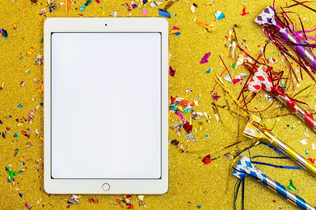 Noisemakers en confetti in de buurt van tablet