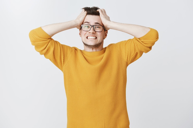 Gratis Foto noodlijdende man in paniek haar gooien en angstig kijken
