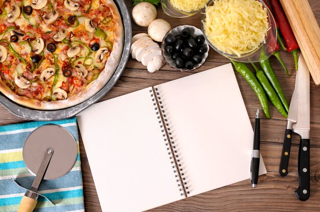 Notebook en pizza boven de tafel