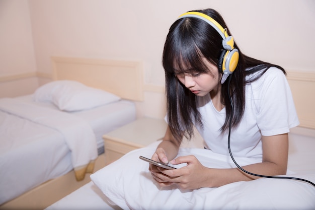 ochtend, vrije tijd, Kerstmis en mensenconcept - gelukkige jonge vrouw in bed thuis slaapkamer