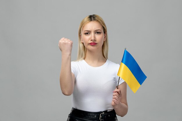 Oekraïne Russisch conflict blond schattig meisje met rode lippenstift en Oekraïense vlag gerichte vuist omhoog