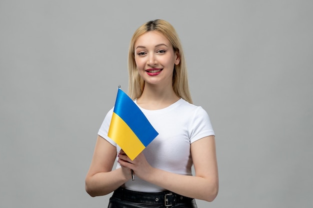 Gratis foto oekraïne russisch conflict blond schattig meisje met rode lippenstift en oekraïense vlag