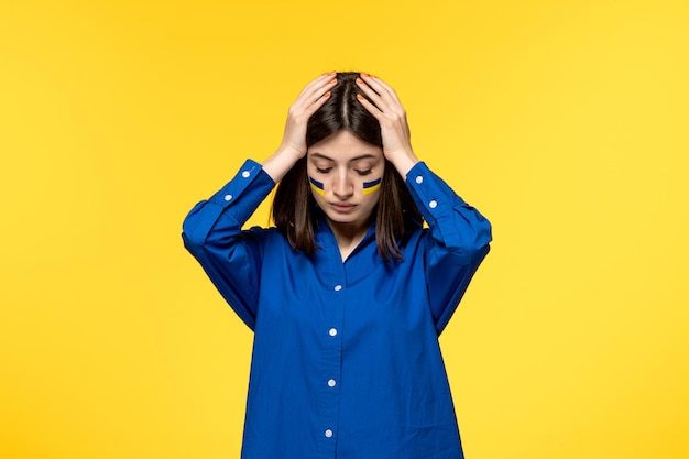 Oekraïne russisch conflict schattig jong meisje in blauw shirt gele achtergrond met hoofd geërgerd