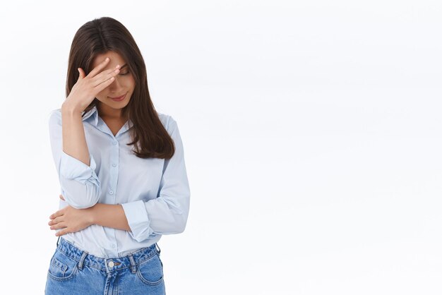 Oh god kijk me niet aan Beschaamde geërgerde brunette vrouw verbergt haar gezicht met facepalm kijk naar beneden en probeer oogcontact te vermijden met haar ex-vriendje doet dom en gênant witte achtergrond