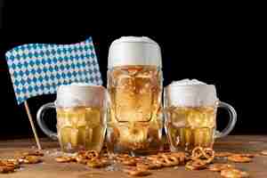 Gratis foto oktoberfest bierpullen met snacks op een tafel