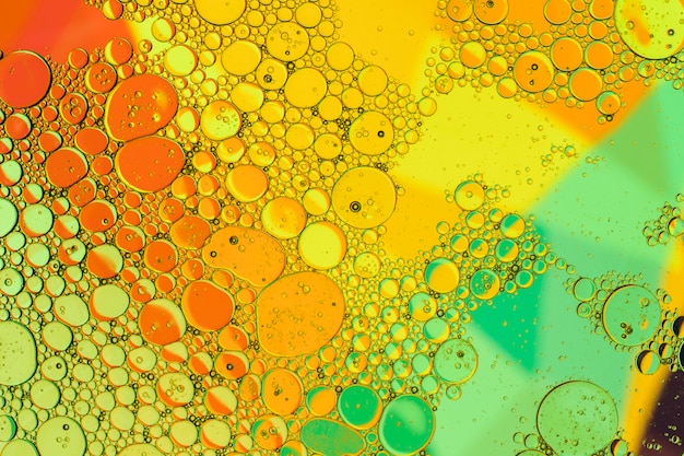 Oliedalingen in water op een gekleurde achtergrond