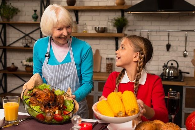 Gratis foto oma en kleindochter kijken elkaar aan en houden het eten vast