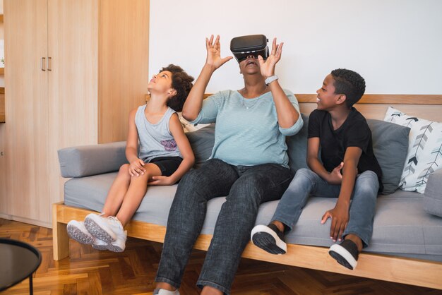 Oma en kleinkinderen spelen samen met een VR-bril.