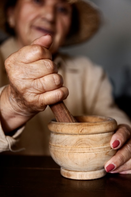 Oma met behulp van vijzel en stamper