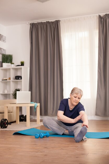 Oma met een gezonde levensstijl doet strektraining