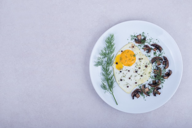 Omelet met gebakken champignons op een witte plaat.