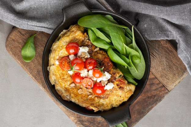 Omelet met kaas en tomaten op snijplank