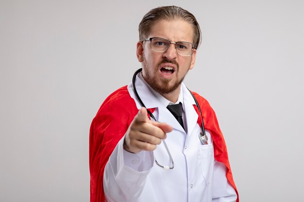 Onaangename jonge superheld man met medische mantel met een stethoscoop en een bril die je toont