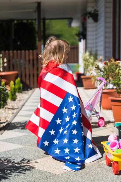 Onafhankelijkheidsdagconcept met meisje in tuin