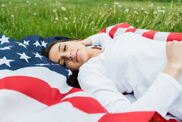 Gratis foto onafhankelijkheidsdagconcept met ontspannen vrouw en amerikaanse vlag