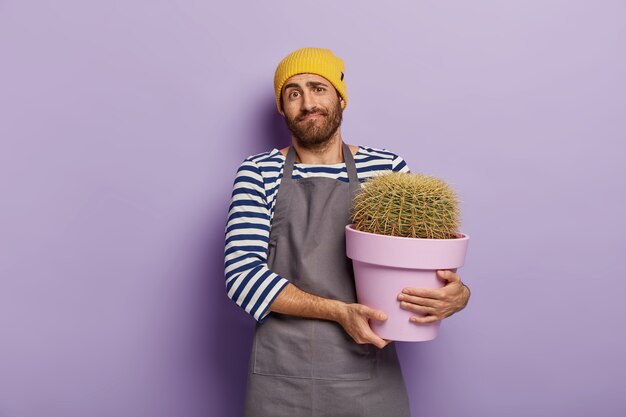 Onbewuste verkoper vormt in bloemenwinkel met pot met cactus