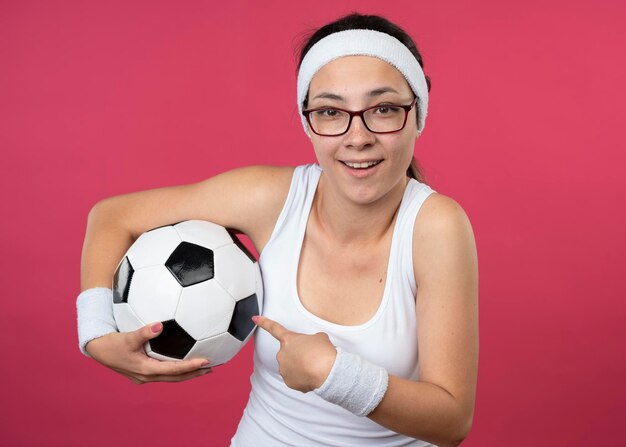 Onder de indruk jong sportief meisje in optische glazen hoofdband dragen