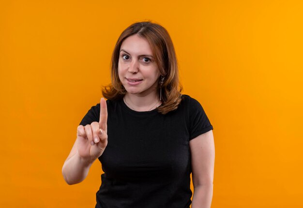 Onder de indruk jonge casual vrouw met opgeheven vinger op geïsoleerde oranje ruimte met kopie ruimte