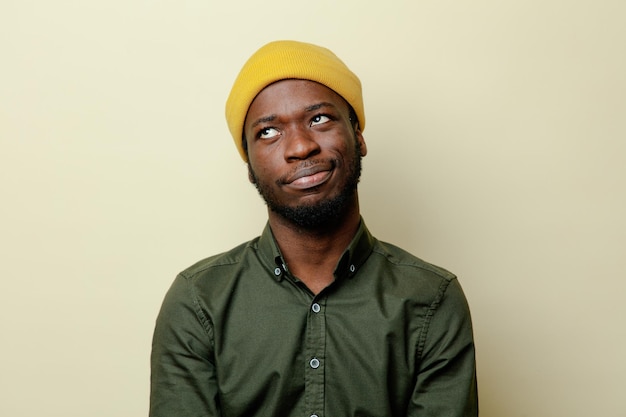 Onder de indruk van jonge afro-amerikaanse man in hoed met groen shirt geïsoleerd op een witte achtergrond Premium Foto