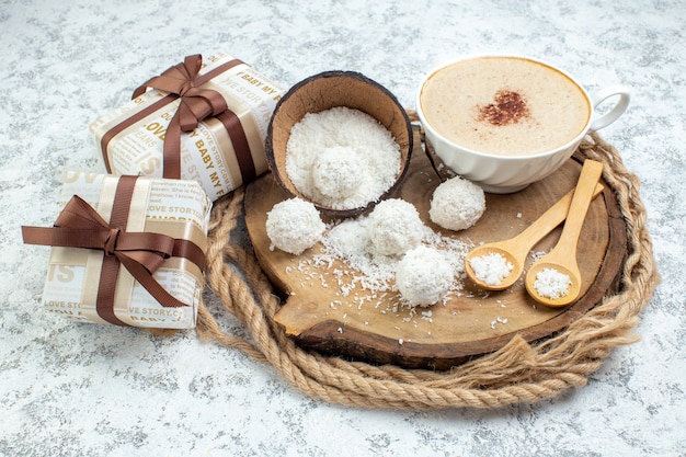 Onderaanzicht cappuccino kopje kokospoeder kom houten lepels op houten plank geschenken op grijze achtergrond