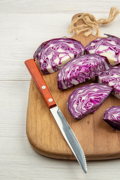 Onderaanzicht gesneden rode kool mes op snijplank op grijze houten tafel