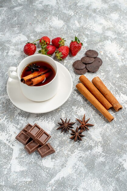 Onderaanzicht kaneel anijszaad thee en wat aardbeien chocolaatjes kaneel anijs zaden op tafel