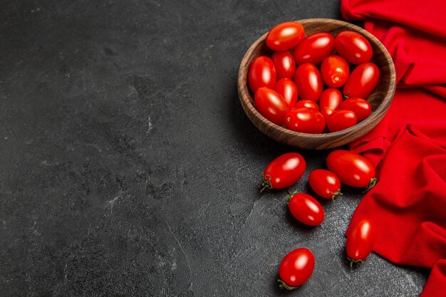 Onderaanzicht kom met cherry tomaten rode handdoek op donkere achtergrond