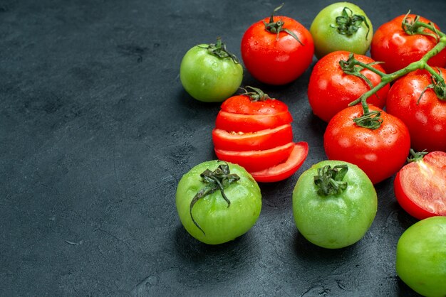 Onderaanzicht tomatentak gehakte tomaten groene tomaten op zwarte tafel met kopieerplaats