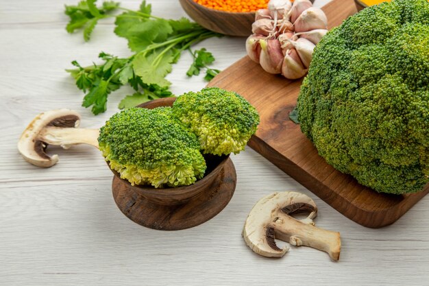 Onderaanzicht verse broccoli knoflook op snijplank champignons peterselie op grijze tafel