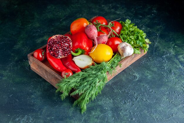 Onderaanzicht verse groenten en halve granaatappel op een houten bord op grijs