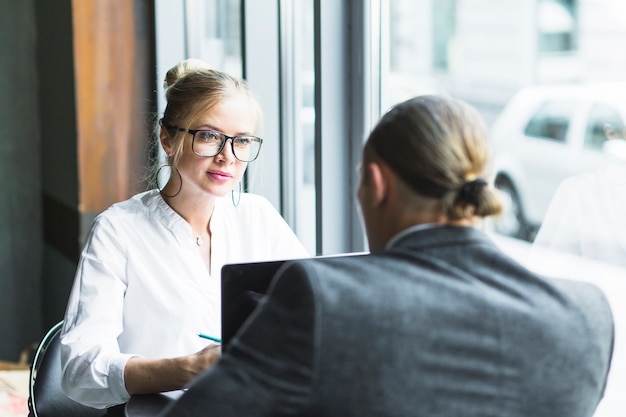 Onderneemster die haar collega bekijkt die in caf� werkt