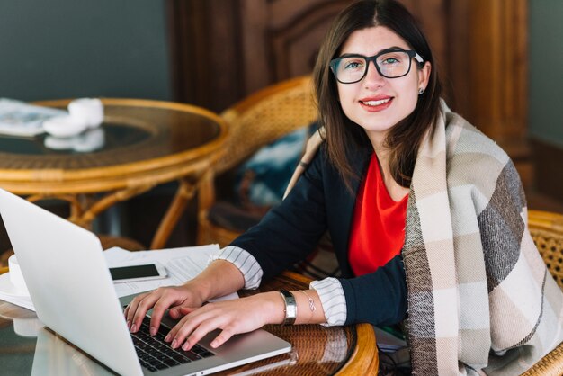 Onderneemster die laptop in koffiewinkel met behulp van