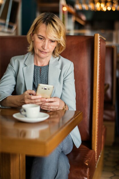 Onderneemster die op afstand van een koffie werkt