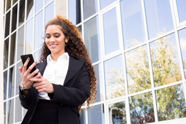 Onderneemster die smartphone bekijkt