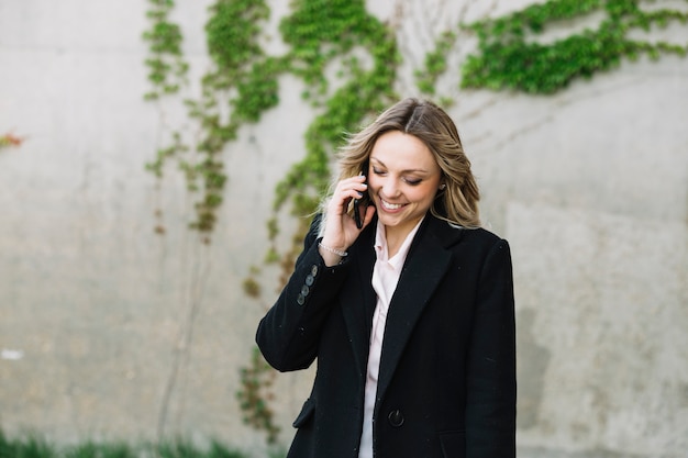 Onderneemster die telefoongesprek in openlucht maakt