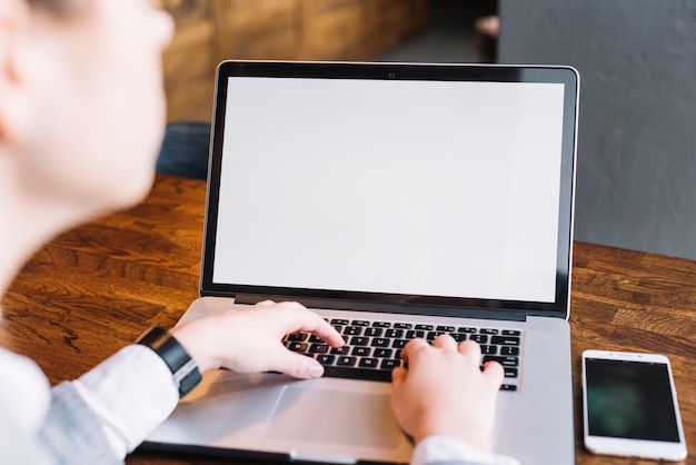 Onderneemster met laptop en smartphone in koffiewinkel